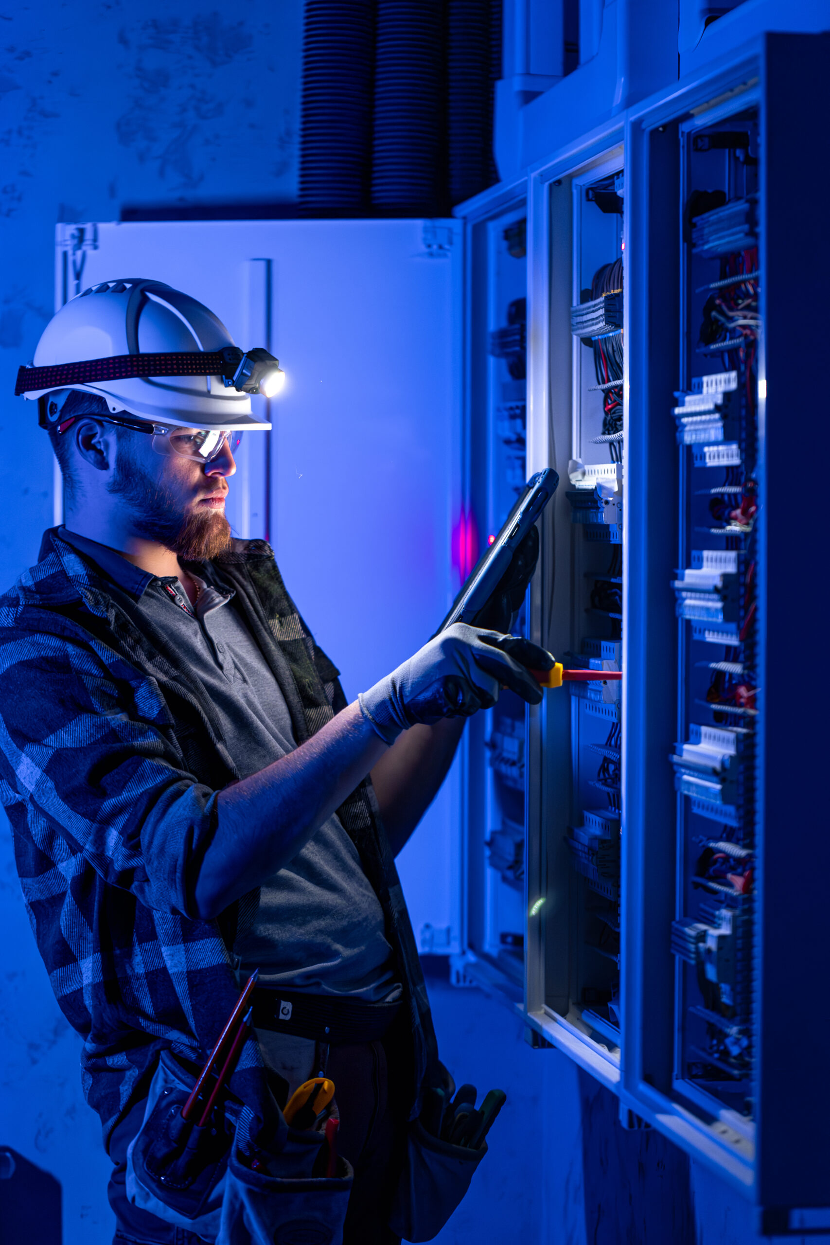 Electrician overalls focused work switchboard with fuses using tablet scaled